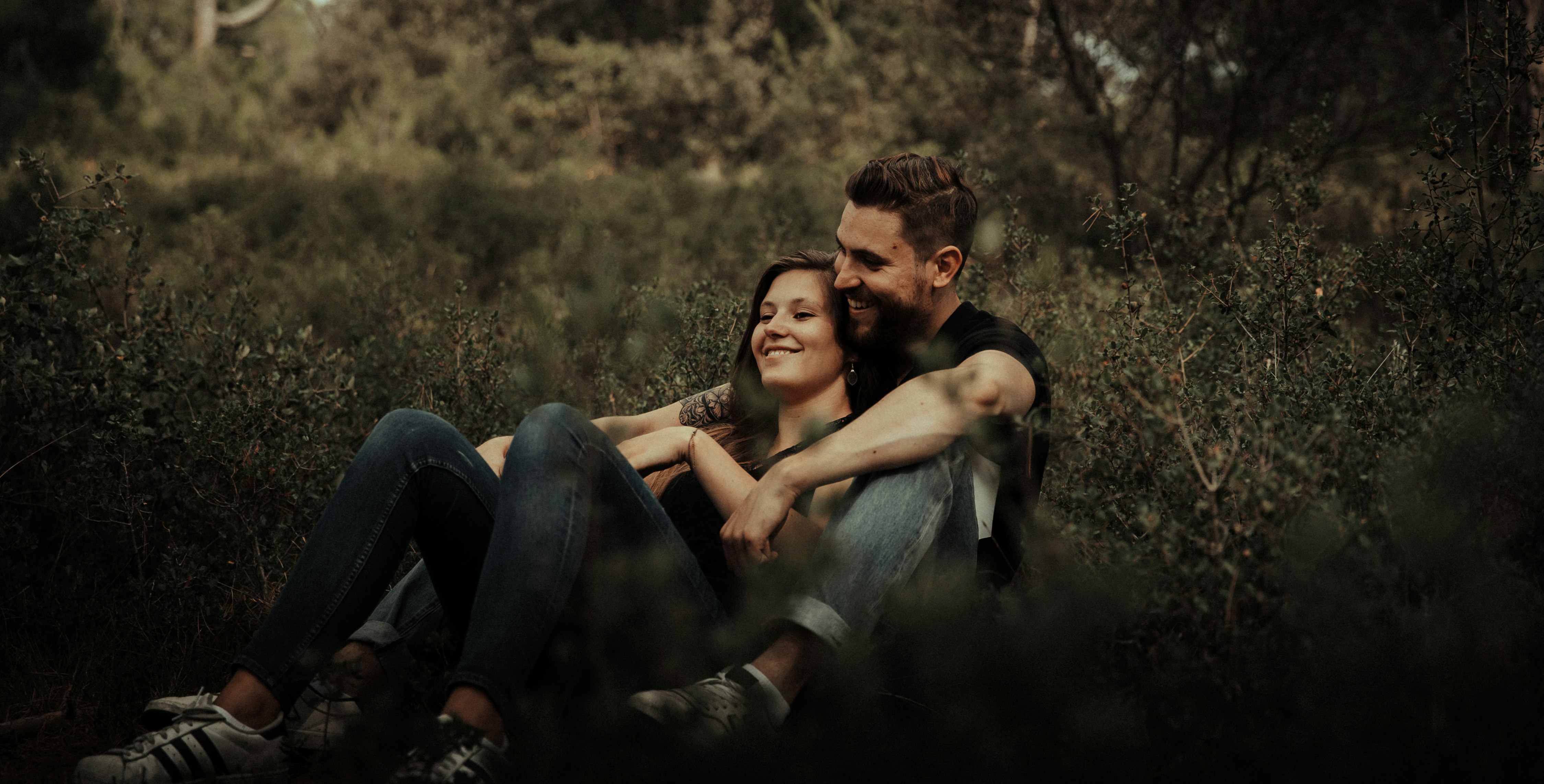 man and woman sitting on grass field